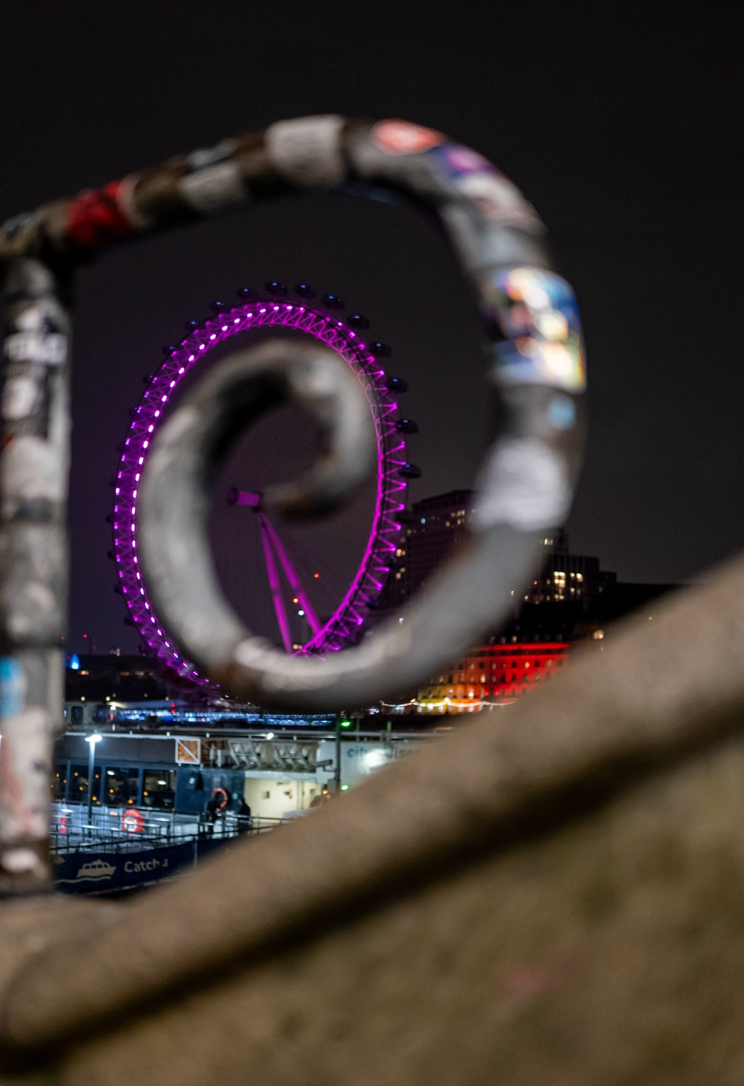 The London Eye seen through a curved foreground detail at night