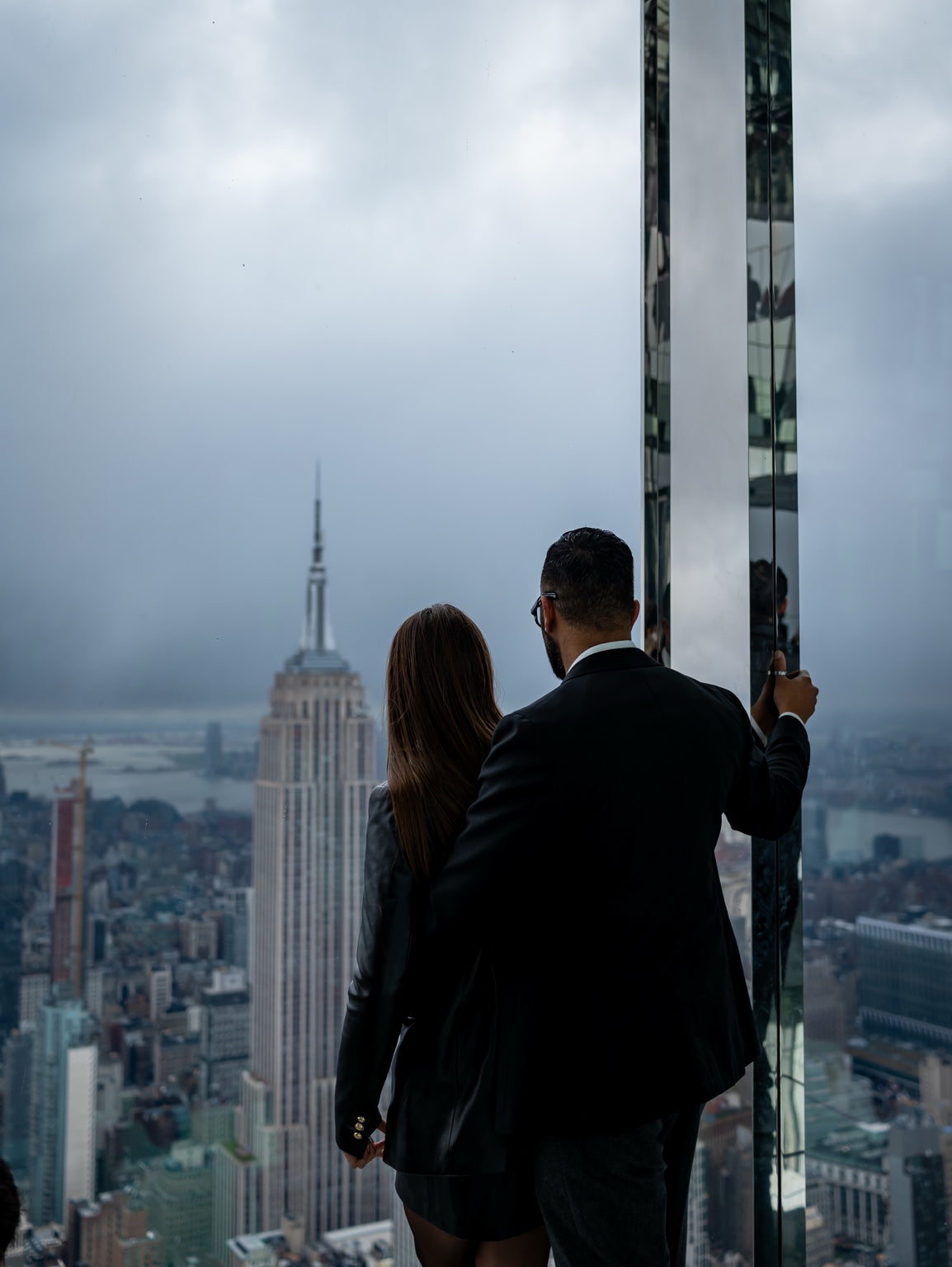 Two visitors overlooking New York from an observation deck