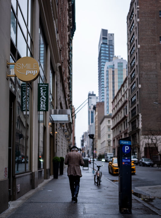A person walking along a city sidewalk