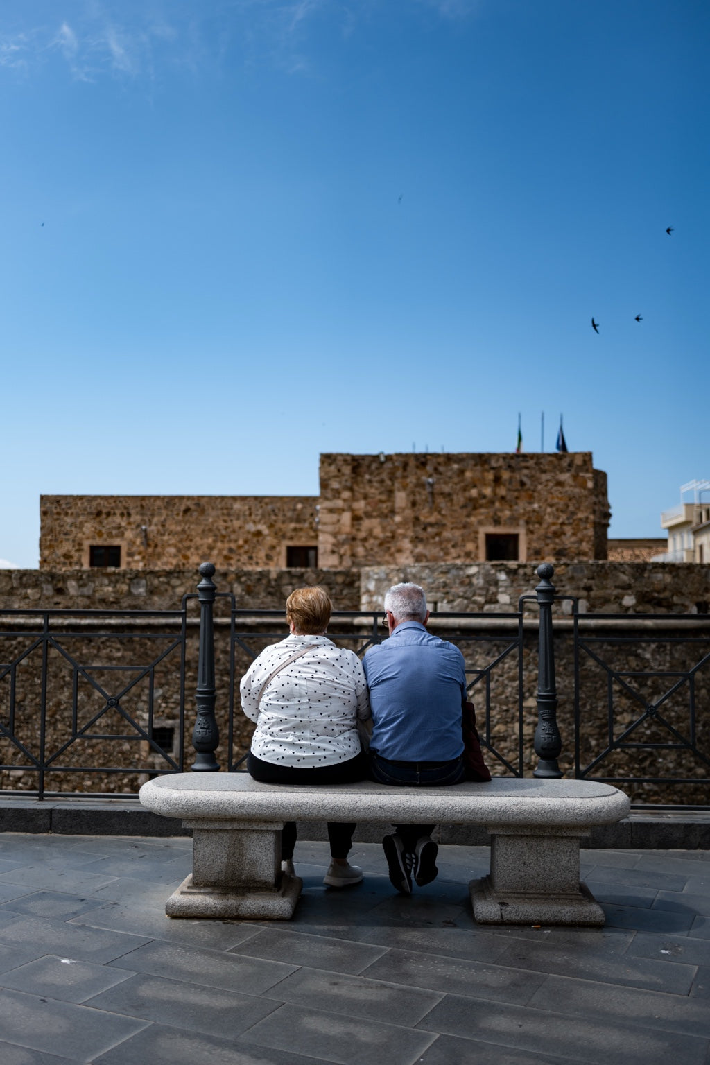 Two people sitting near a coastal castle
