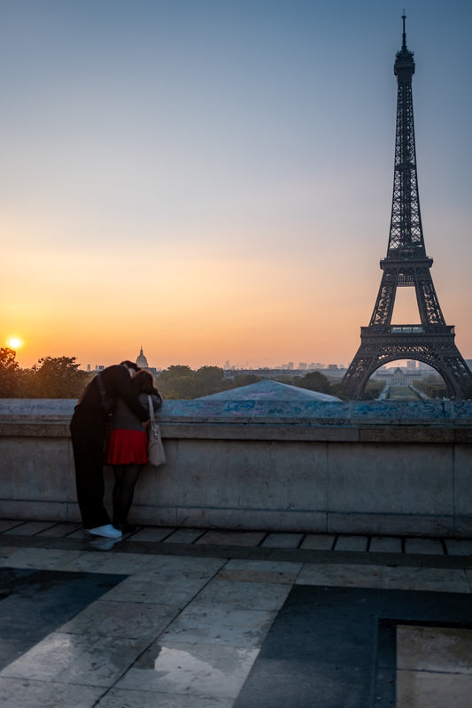 A visitor watching the Eiffel Tower at sunset