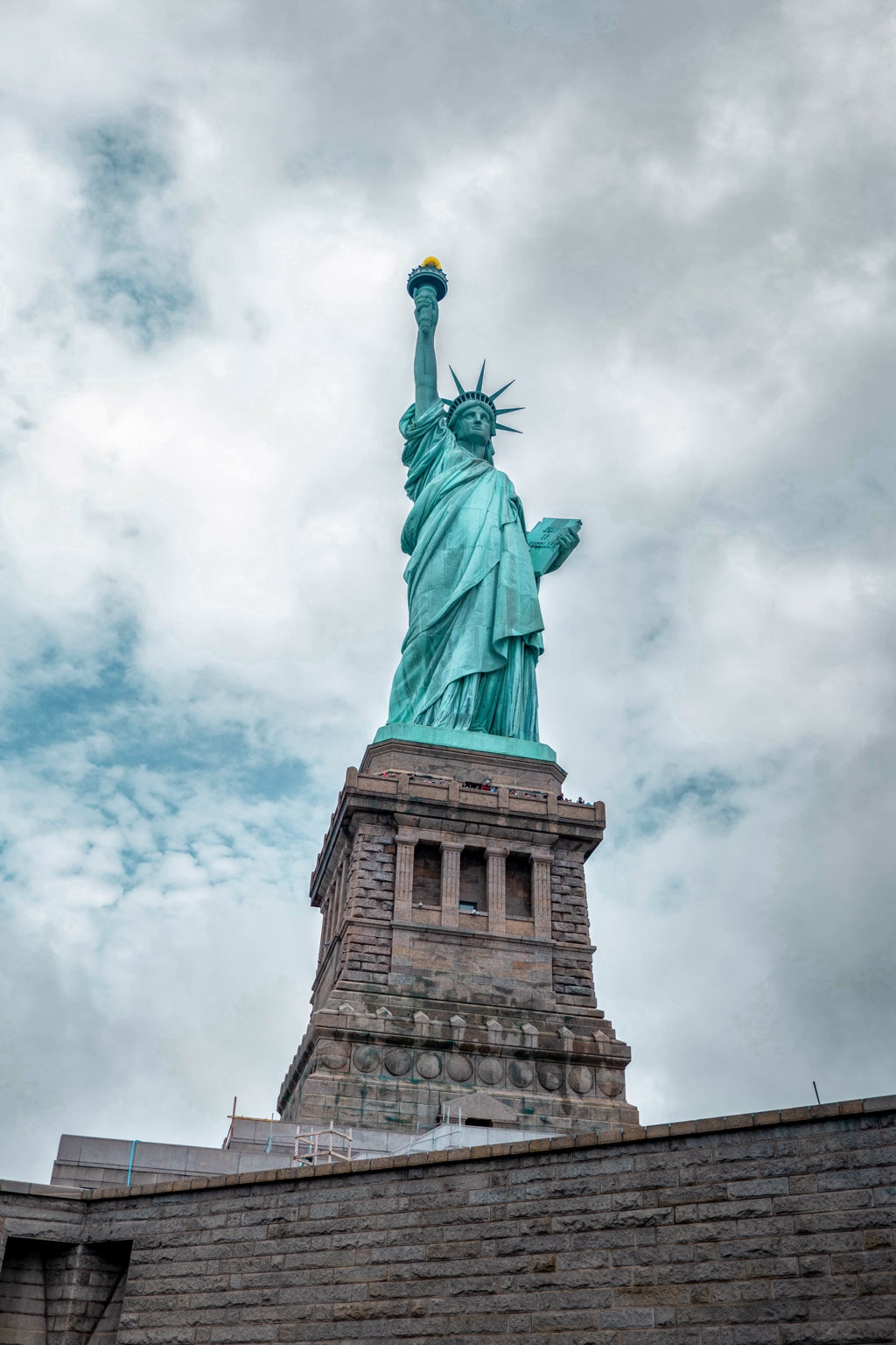 The Statue of Liberty beneath a cloudy sky