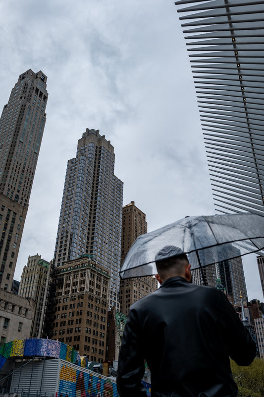 A person with an umbrella beneath tall buildings in New York