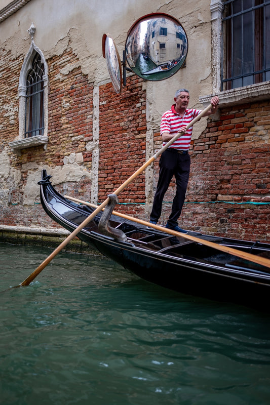 A gondolier beneath a Venetian clock tower