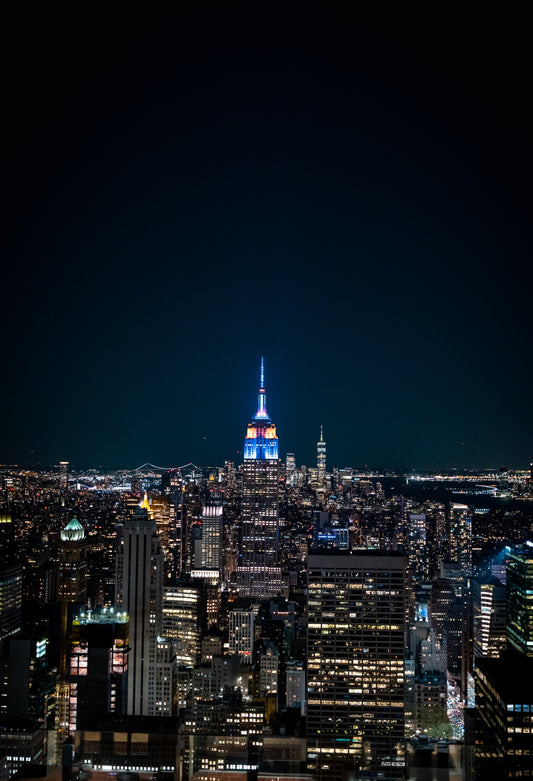 New York skyline with the Empire State Building lit blue at night
