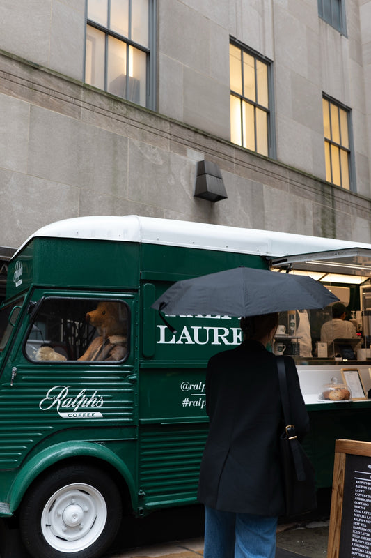 A green food truck and pedestrians in New York
